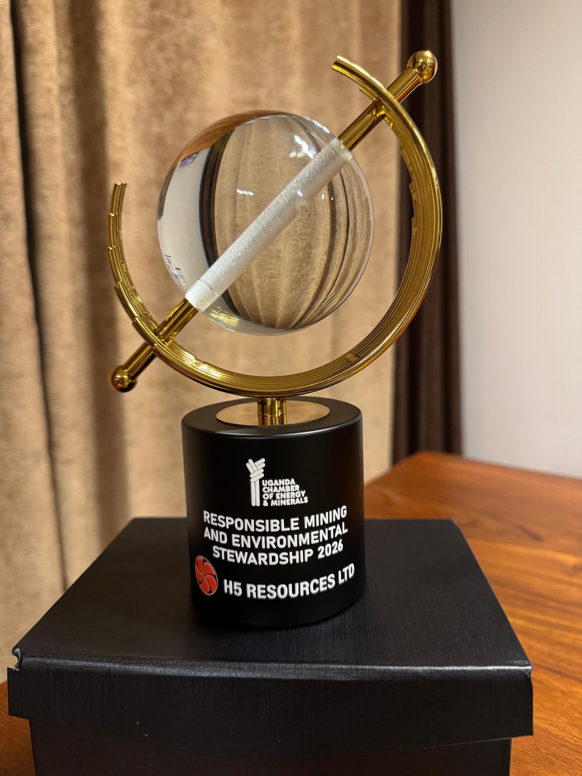 A crystal globe in a gold ring on a black base engraved Responsible Mining and Environmental Stewardship 2026, H5 Resources Ltd.